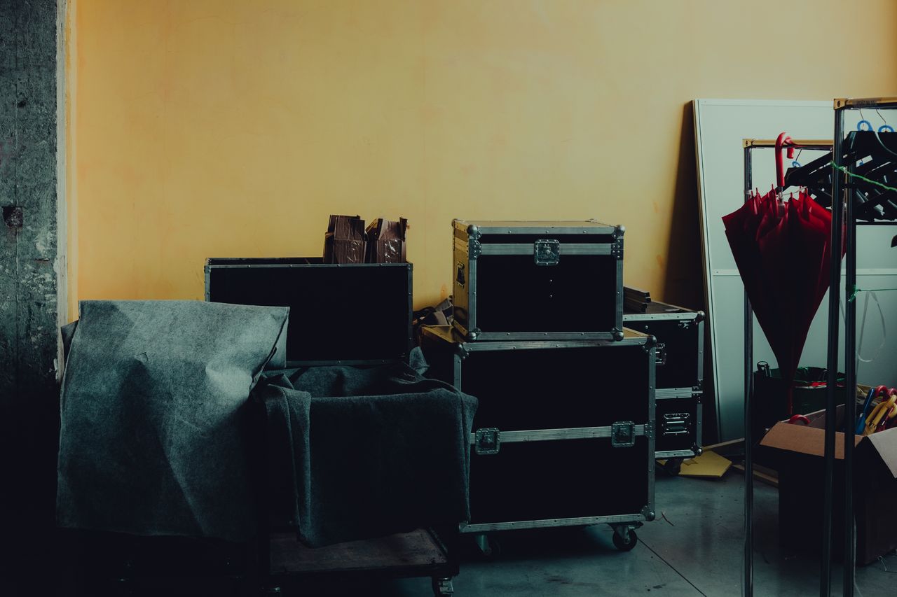 hero-img Many boxes and huge iron cases near umbrella placed in room with yellow walls